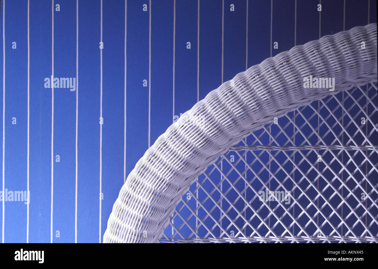 Bianco vimini testiera del letto e a strisce blu parete Camera da Letto Foto Stock