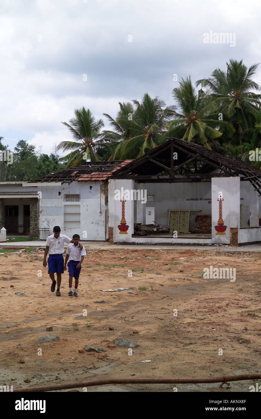 Due ragazzi attraversando a piedi area giochi a scuola colpite dal maremoto, Hegalla M V Scuola, Sri Lanka, Asia Foto Stock