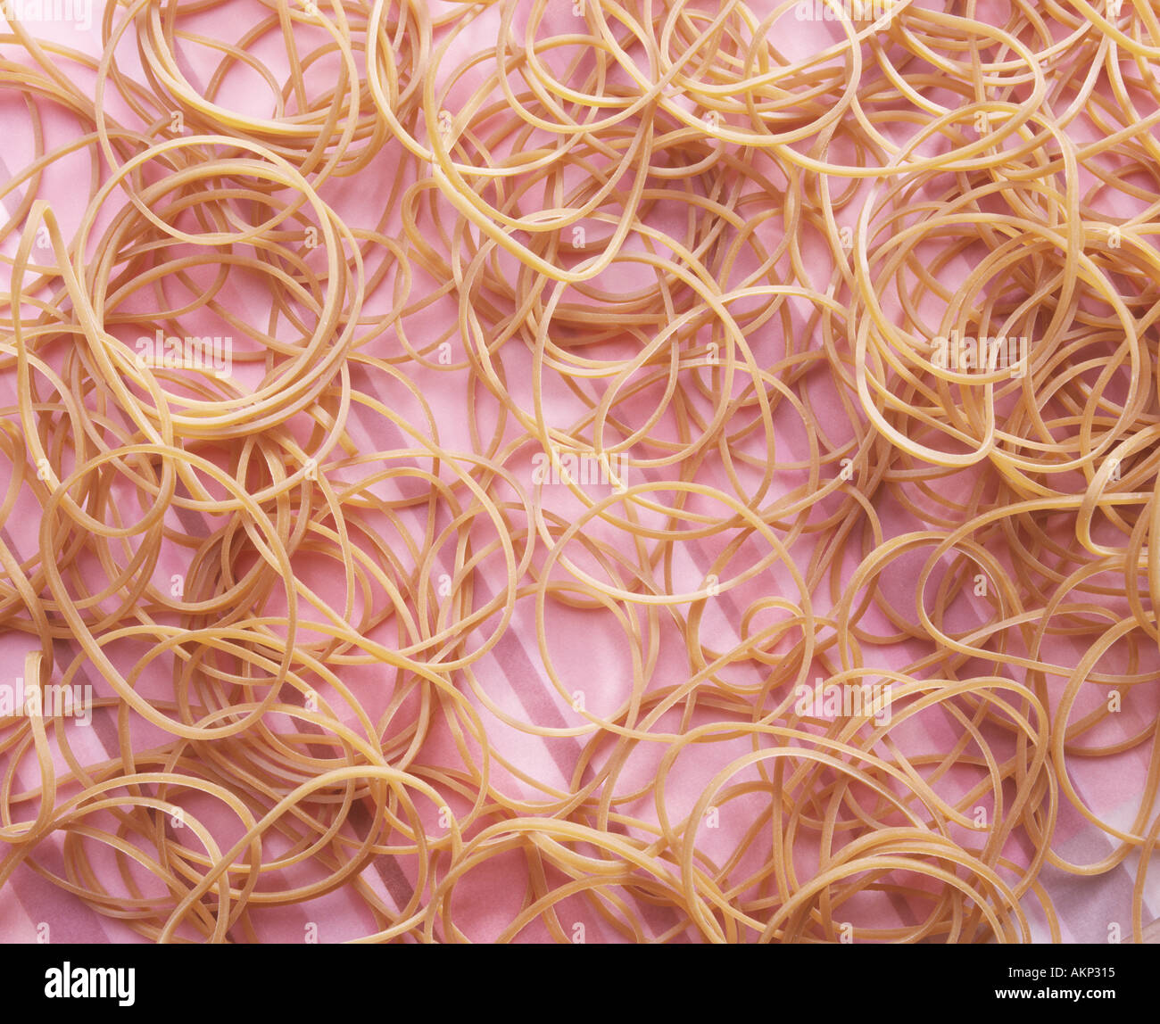 Molti sottili bande di gomma sul rosa superficie striata Foto Stock