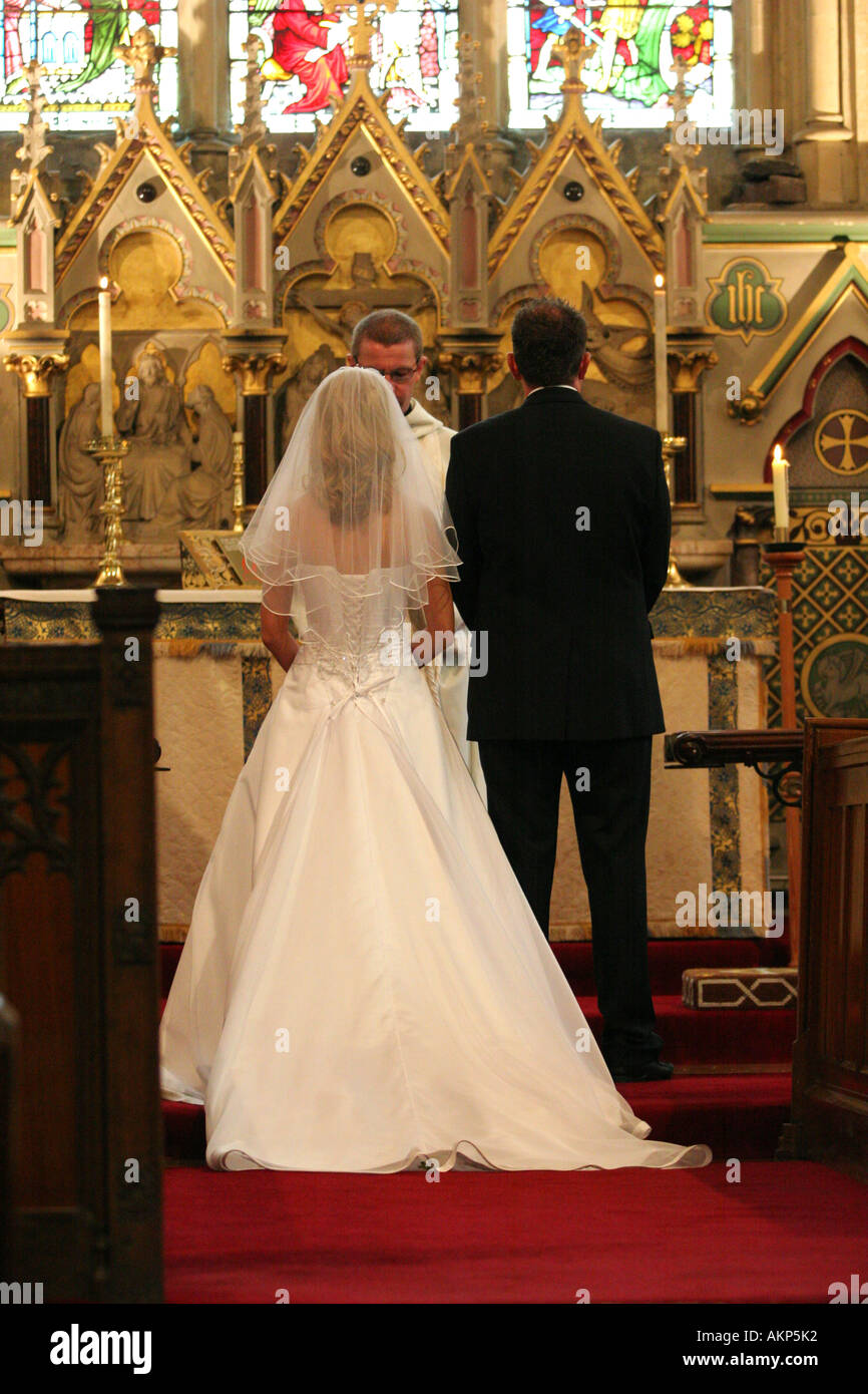 La sposa e lo sposo stand presso l'altare durante la loro chiesa tradizionale cerimonia di nozze service UK Foto Stock