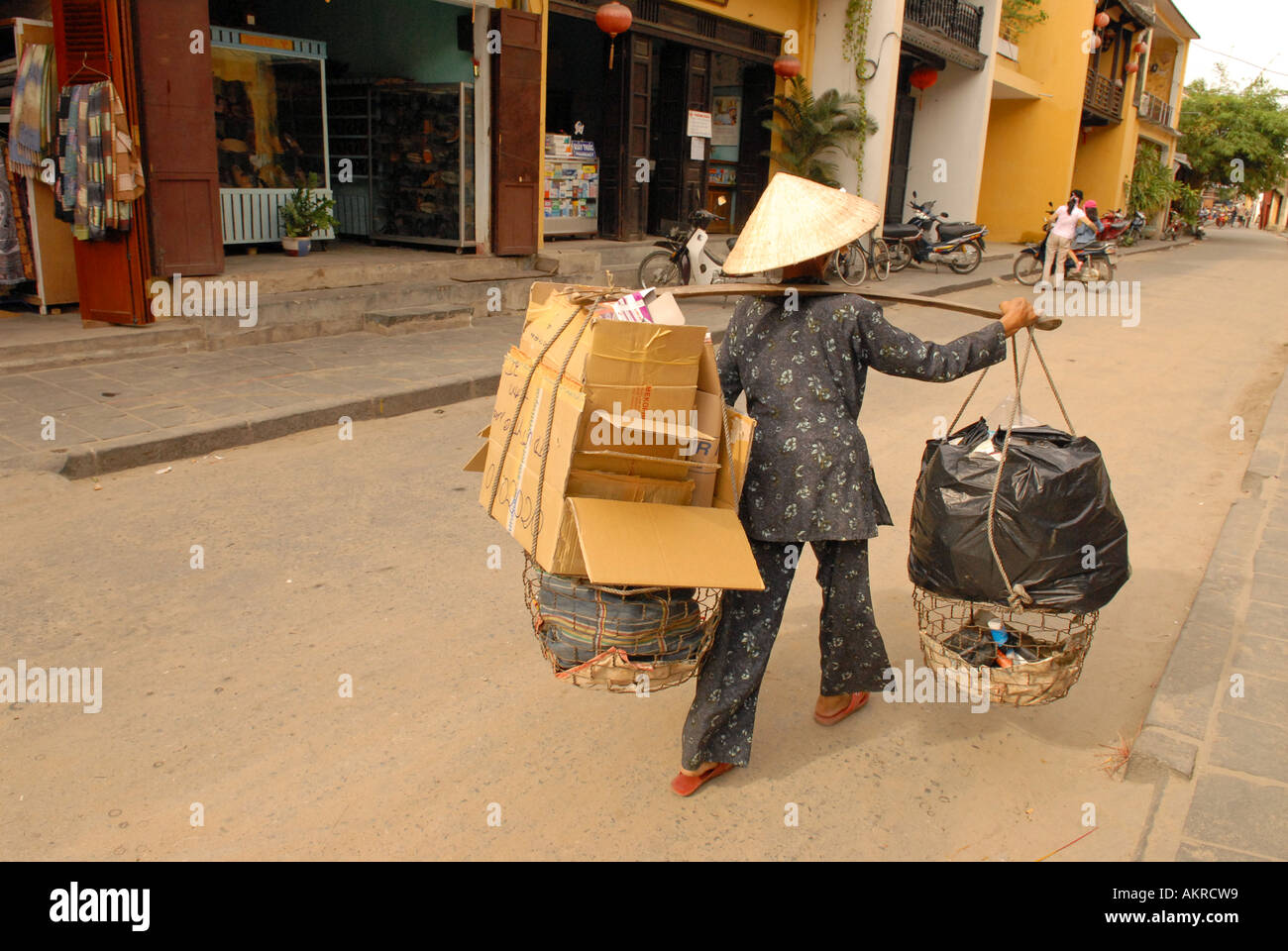 Donna di trasporto di merci su strada di Hoi An old town Vietnam Foto Stock