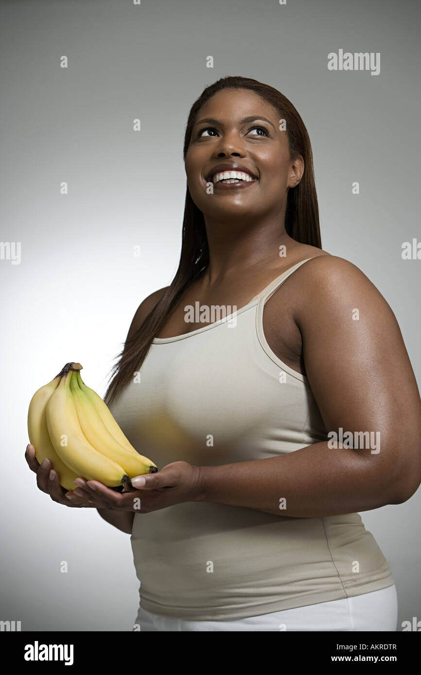 Donna che mantiene le banane Foto Stock