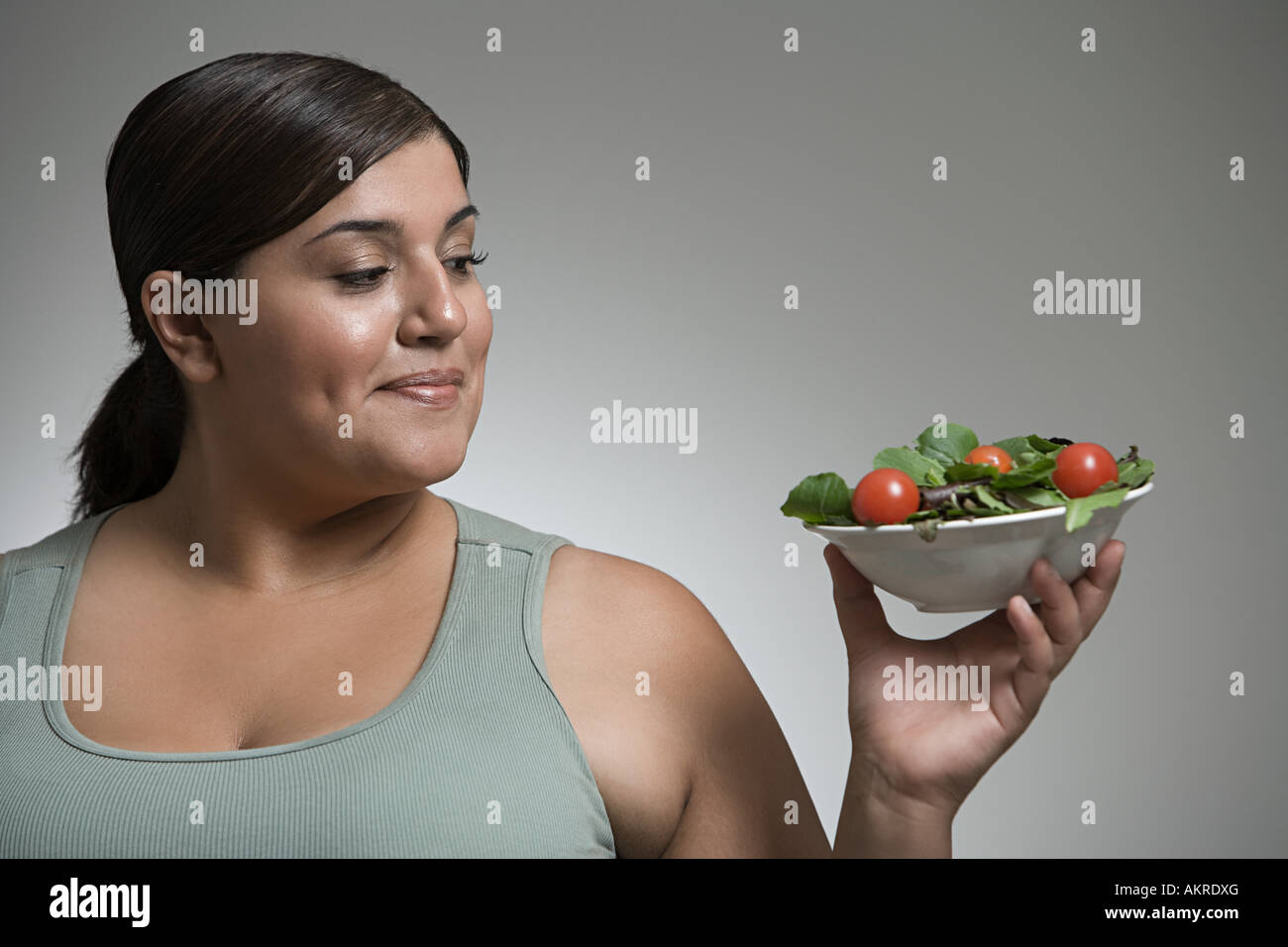 Donna che guarda la ciotola di insalata Foto Stock