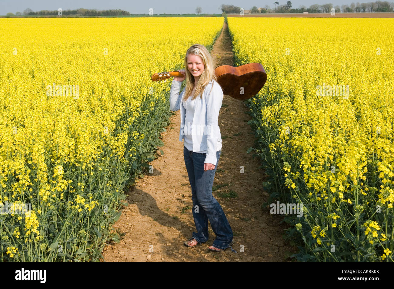 La donna nel campo con la chitarra Foto Stock