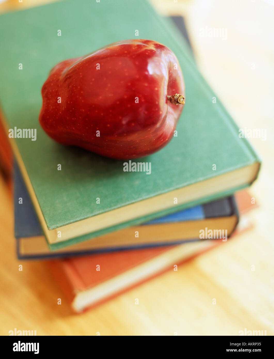 Scuola ancora vita con mela rossa sulla parte superiore della pila di libri Foto Stock