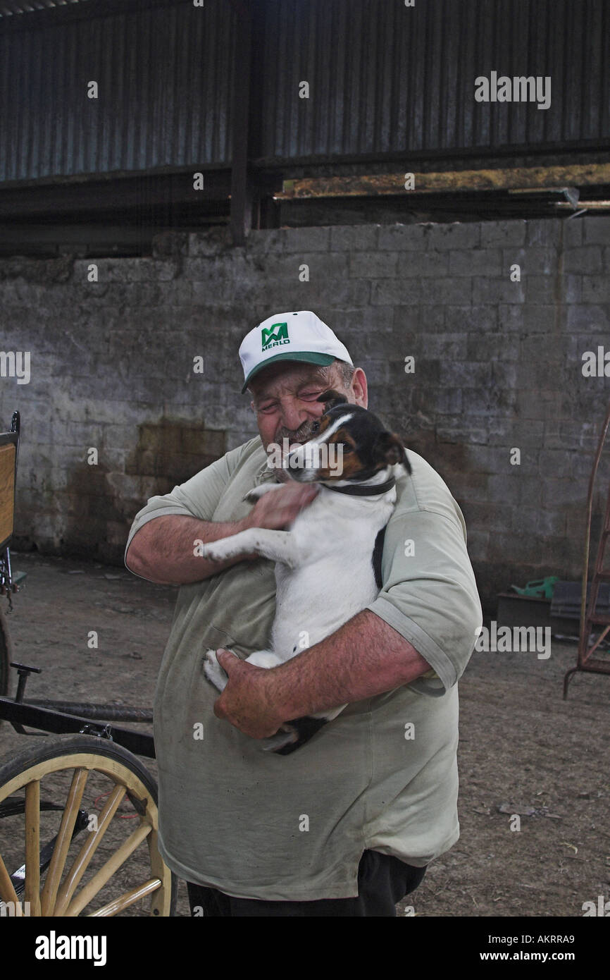 L'uomo cuddling un cane Foto Stock