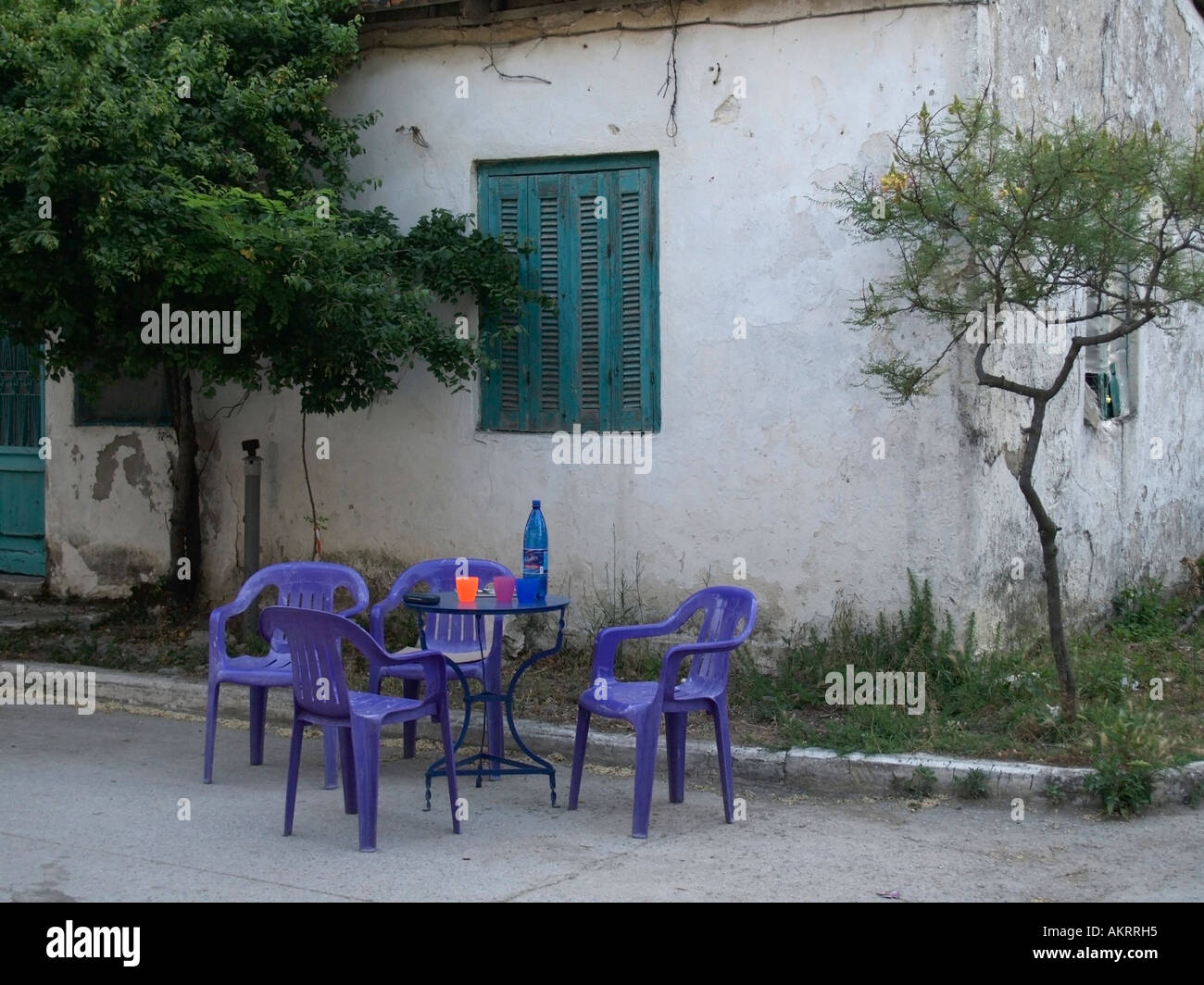 Blue giardino di plastica posti a sedere di fronte a un semplice kafenion coffee bar in Grecia Foto Stock