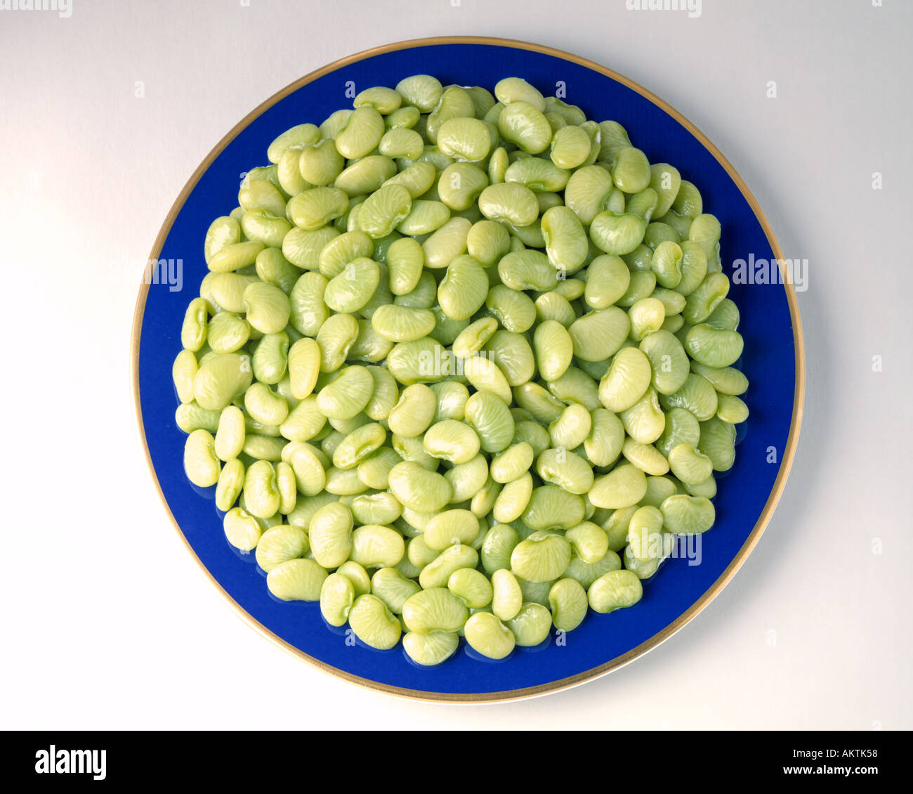 Piccolo bimbo verde fagioli di lima su oro blu piastra rim verdure congelate Bon Appetit il burro I fagioli Foto Stock