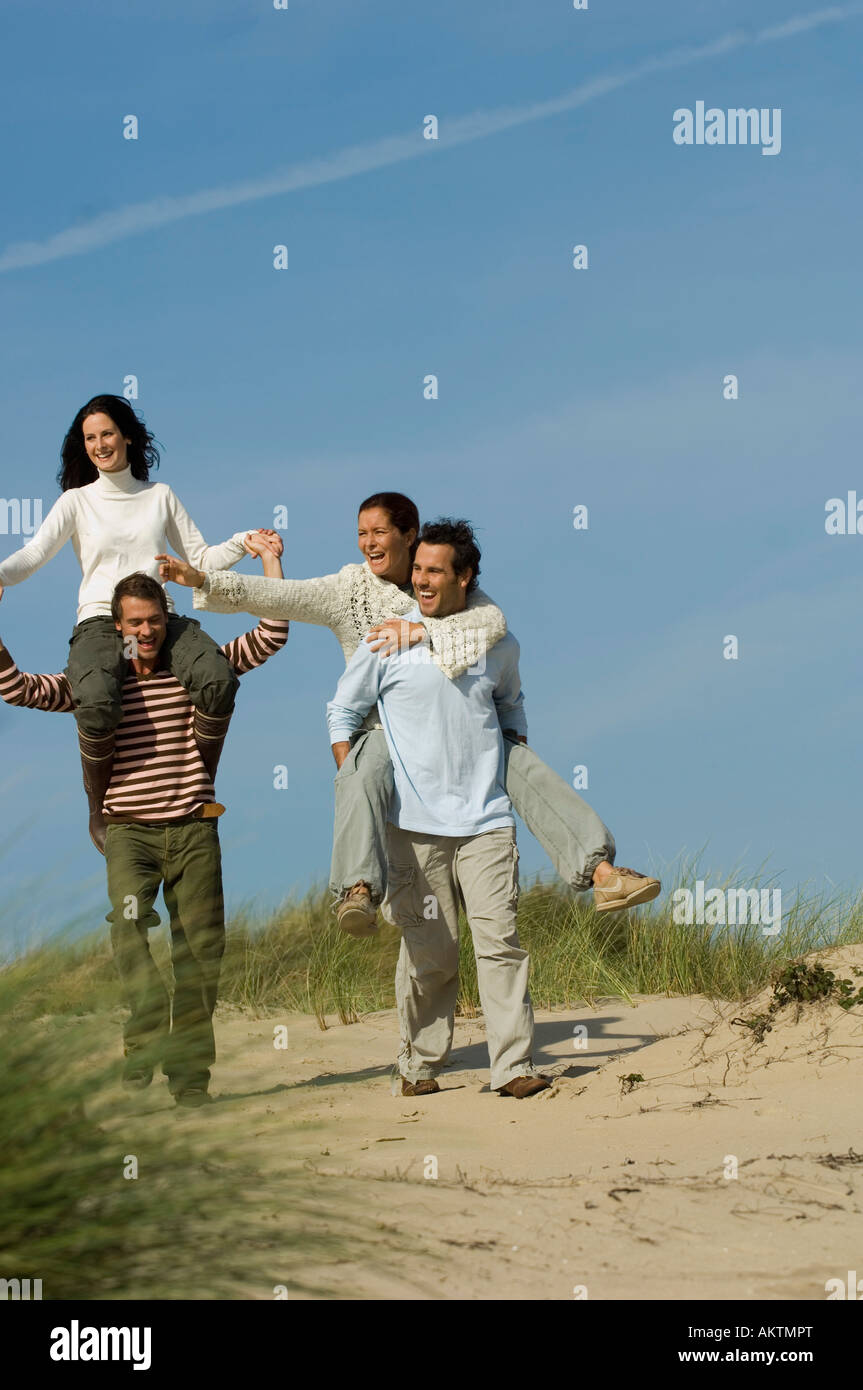 Amici a piedi nelle dune di sabbia e divertimento Foto Stock