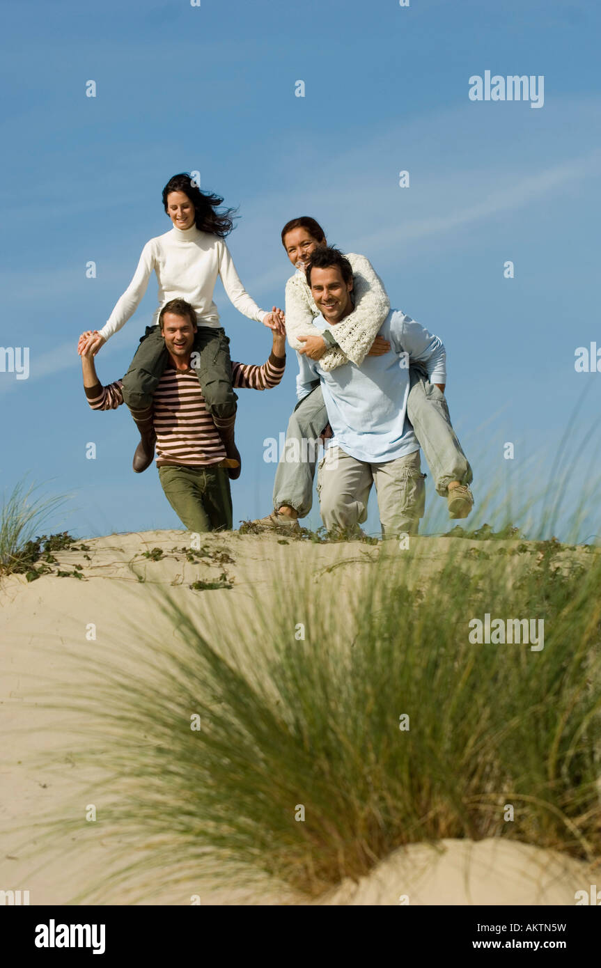 Amici a piedi nelle dune di sabbia e divertimento Foto Stock