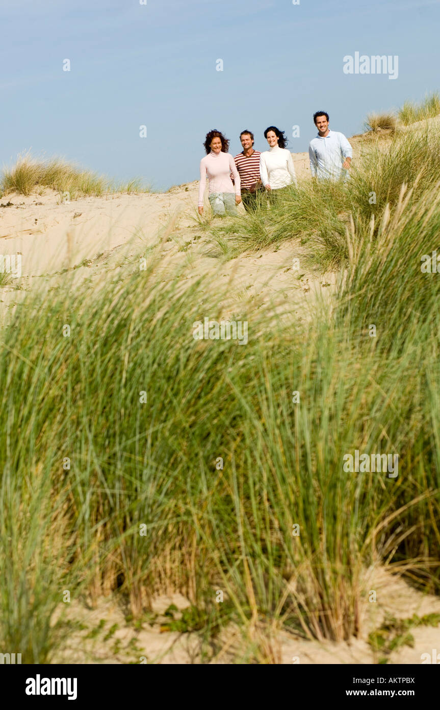 Quattro amici di camminare sulla spiaggia, rilassante Foto Stock