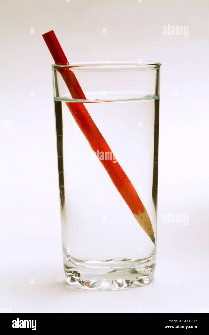 Una matita in un bicchiere di acqua che mostra la distoprtion ottico causato dalla rifrazione dell'immagine Foto Stock