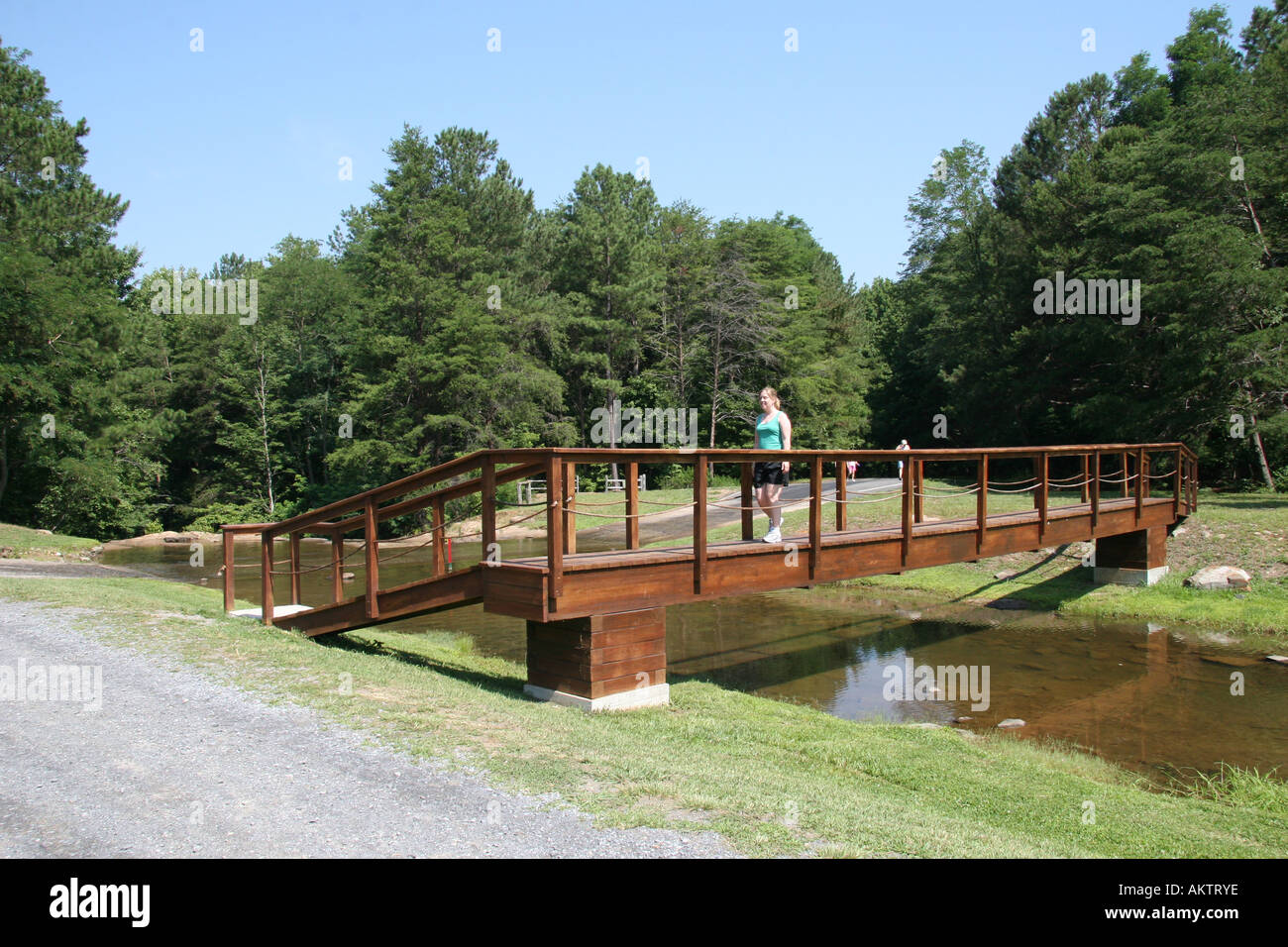 Attraversando un ponte pedonale oltre un flusso, struttura piegata, Jasper, Georgia, Stati Uniti d'America. Foto Stock