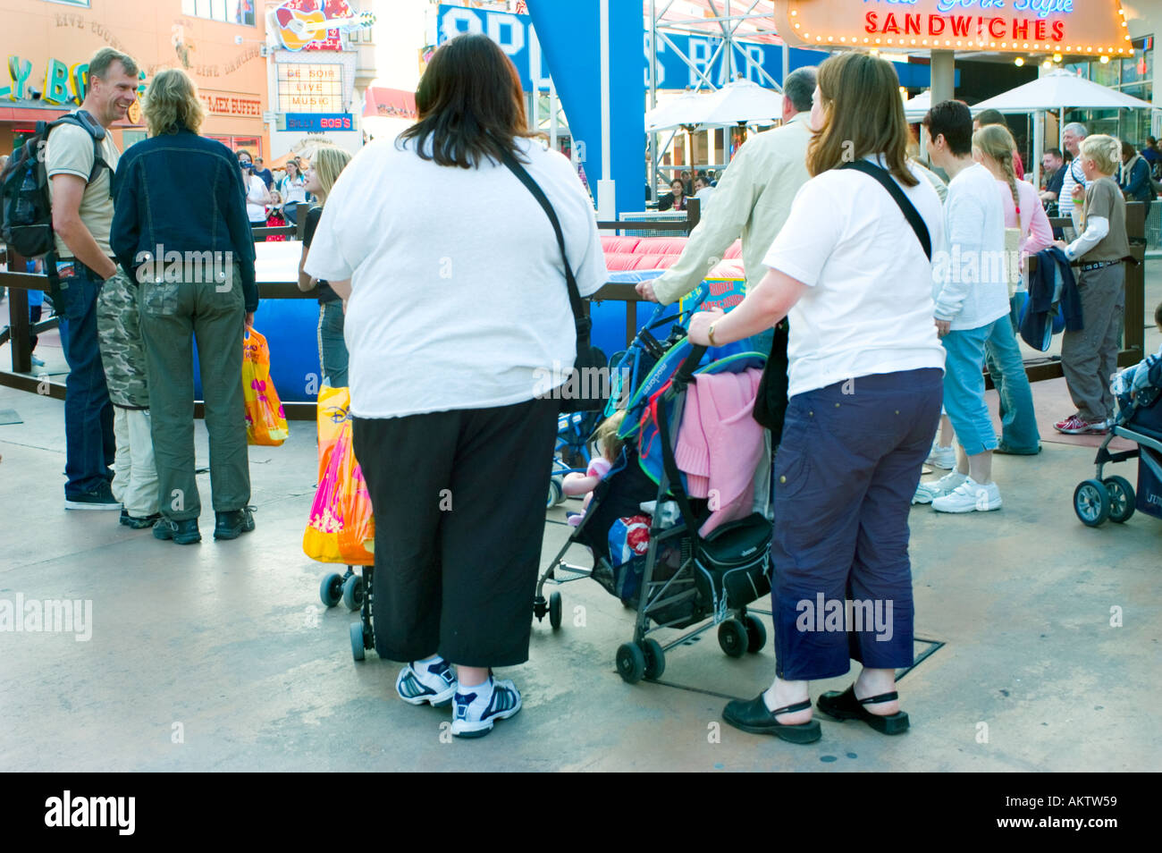 Parigi Francia, parchi divertimenti 'disneyland paris' sovrappeso mamme in 'Disney village' a piedi con carrozzine Foto Stock