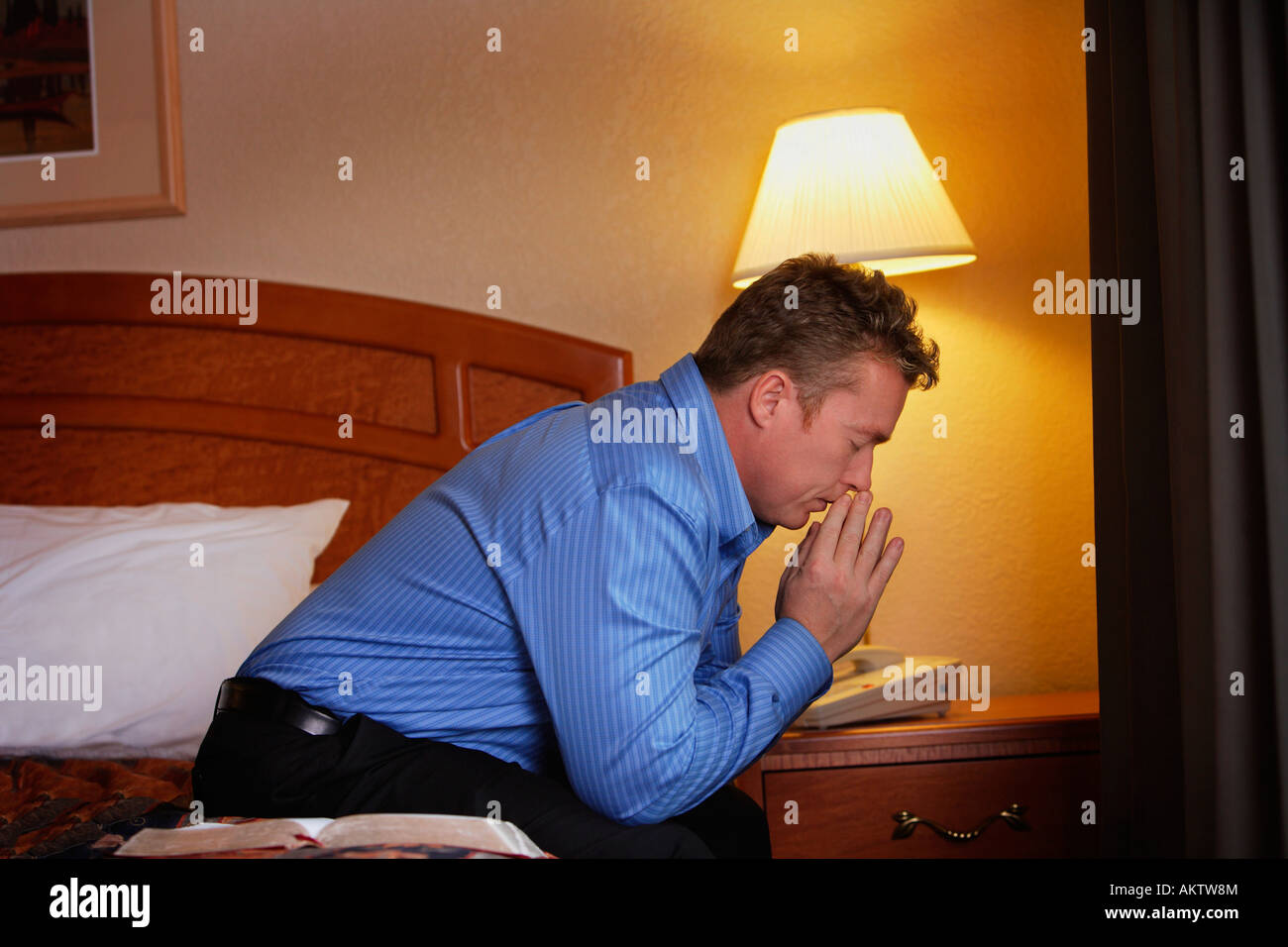 Un uomo che prega al suo capezzale Foto Stock