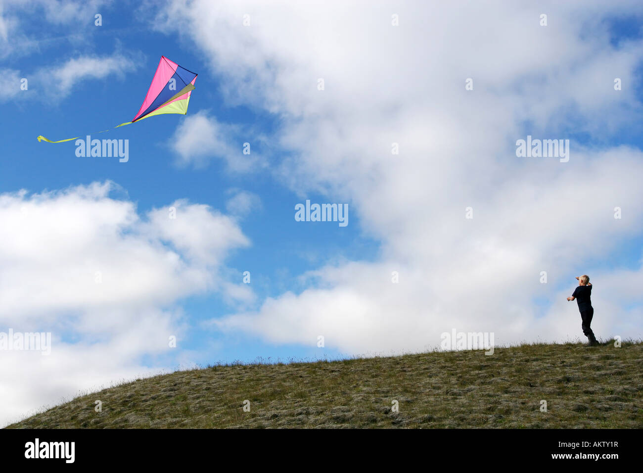 Giovane ragazzo su una collina battenti la sua kite Foto Stock