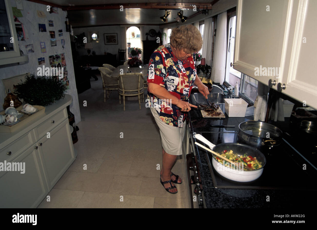 Navigazione sui fiumi olandese il mittente in moglie la cottura nella cucina della nave Foto Stock