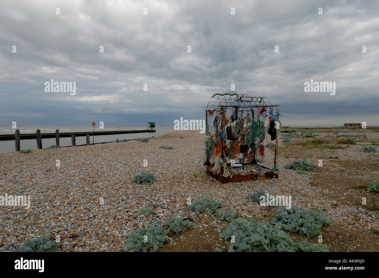 Opera d'arte consistente di rifiuti raccolti sulla ghiaia al di sopra della bocca del fiume Rother Foto Stock