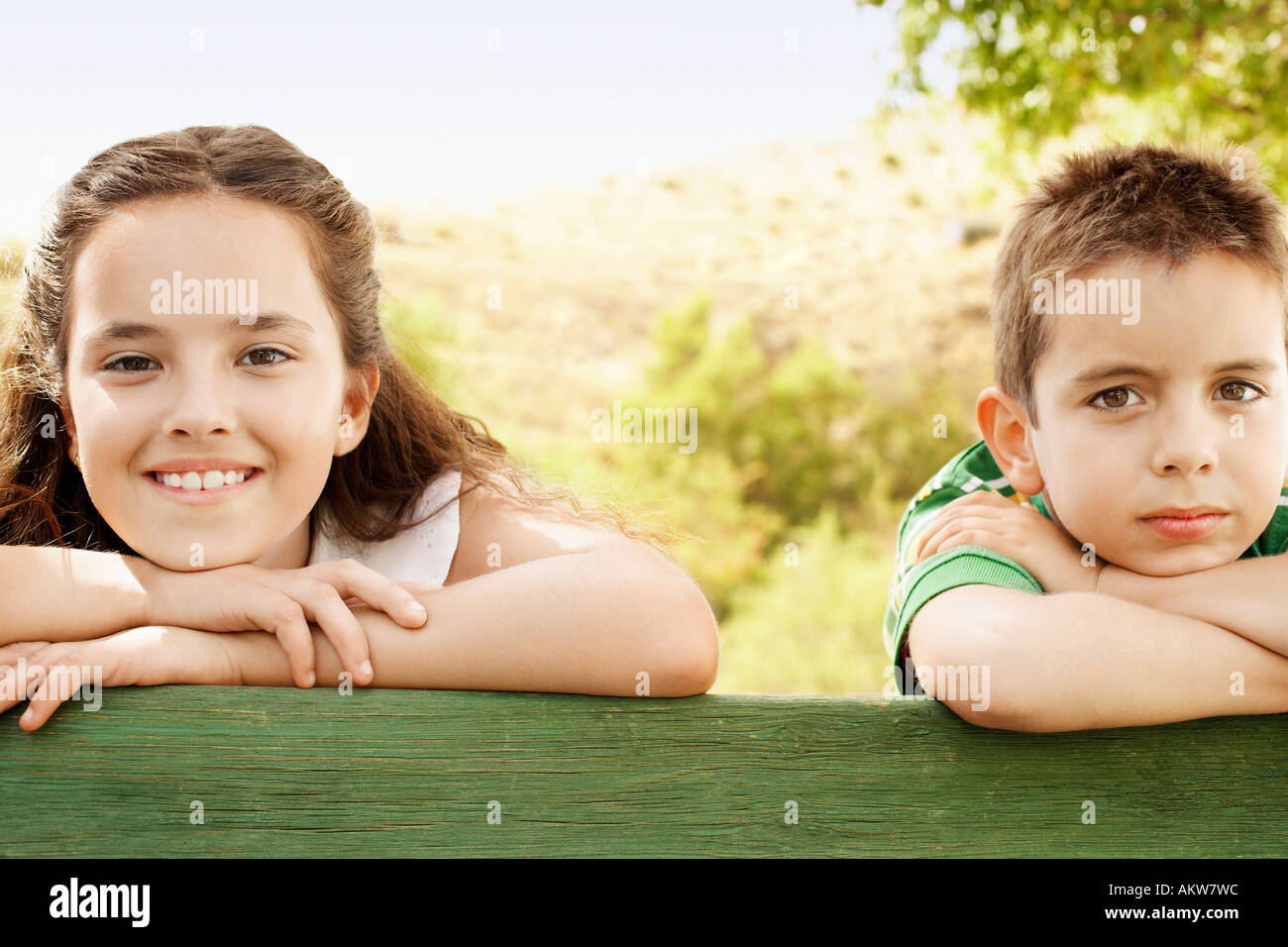 Ragazzo (7-9) e la ragazza (10-12) appoggiata contro la ringhiera, ritratto. Foto Stock