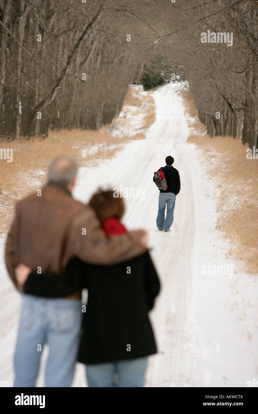 Un ragazzo adolescente percorrendo a piedi una coperta di neve il percorso Foto Stock