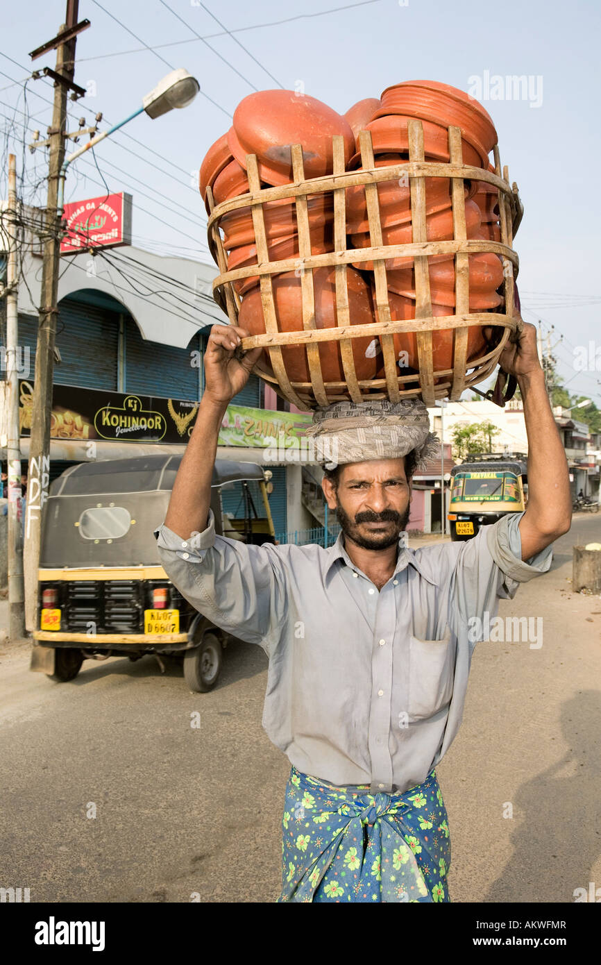 INDIA Kerala fort Cochin uomo cestello di trasporto di vasi di ceramica sulla sua testa Foto Stock