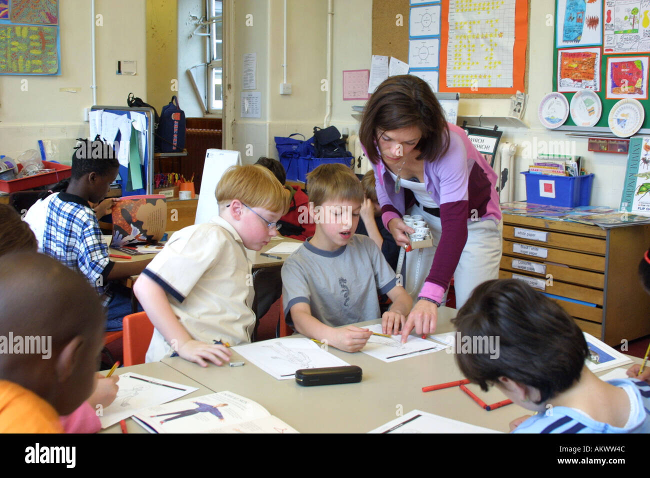 I bambini della scuola elementare studiare anatomia in aula con docente aiutare Foto Stock