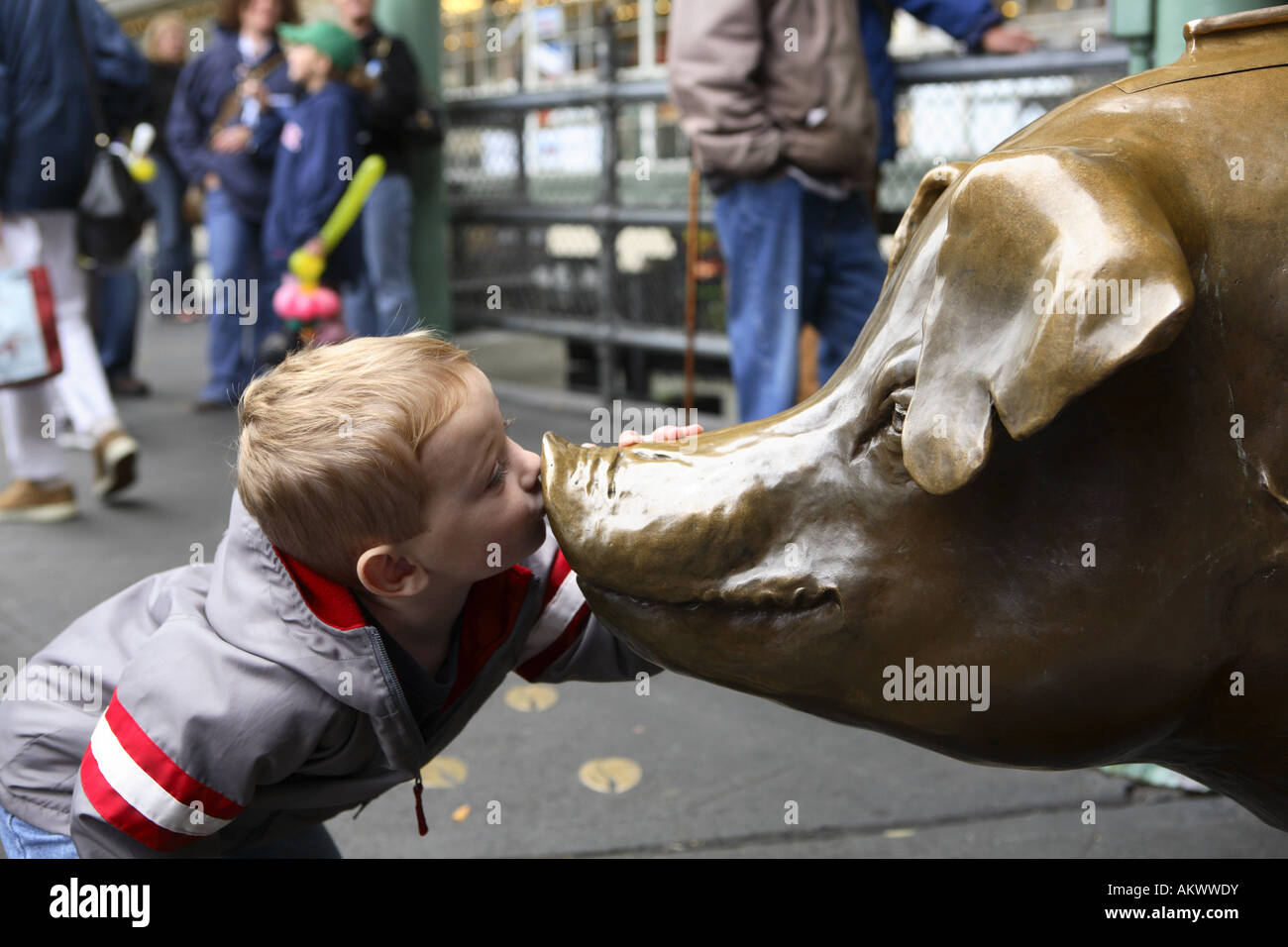 Ragazzo baciare la statua di maiale a s Pike Place Market Seattle Foto Stock