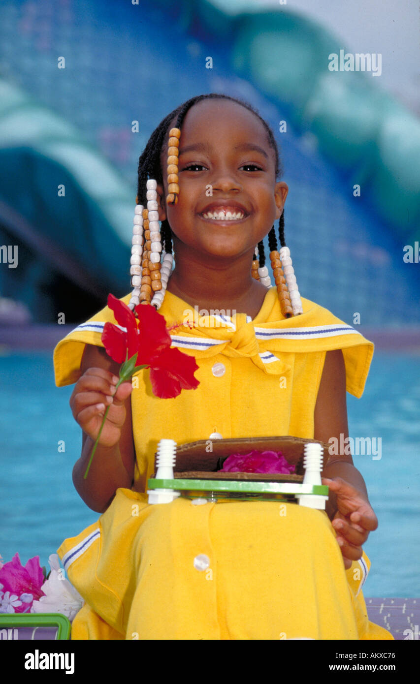 AFRICAN AMERICAN GIRL 6 tenendo un fiore di ridere ritratto 6 anno vecchia ragazza Foto Stock