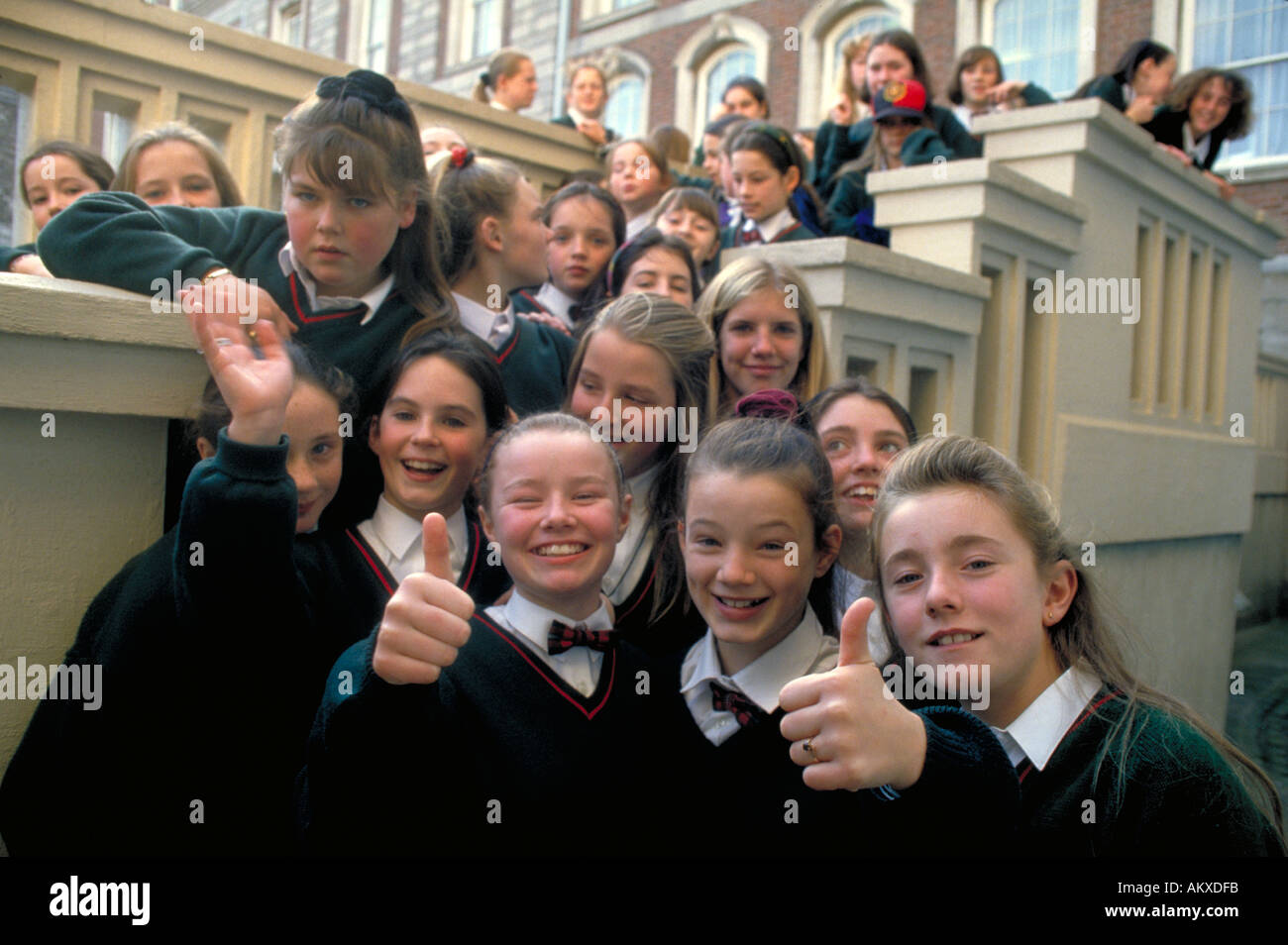Un gruppo di studentesse sorridente rivestita di uniformi scolastiche costituiscono per la telecamera durante una gita al Palazzo Reale a Dublino Foto Stock