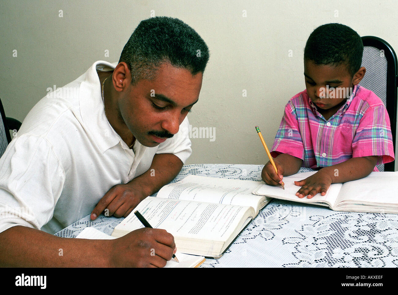 Pre schooler gioca fingere mentre padre studi Foto Stock