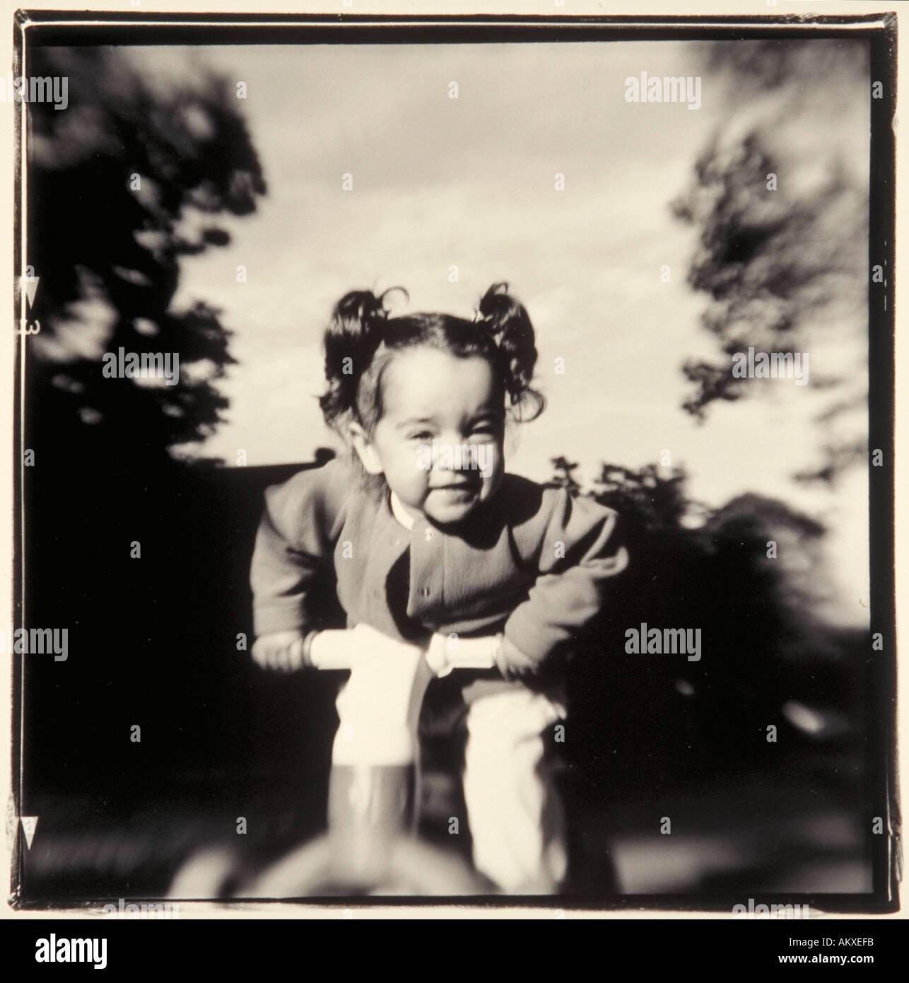 Giovane ragazza sul triciclo di plastica Foto Stock