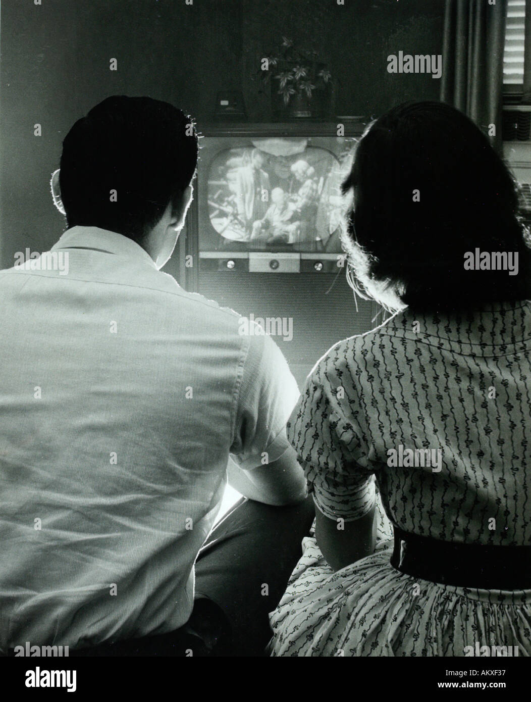 Due adolescenti con spalle verso la telecamera guarda la televisione vintage nel 1950 s Foto Stock