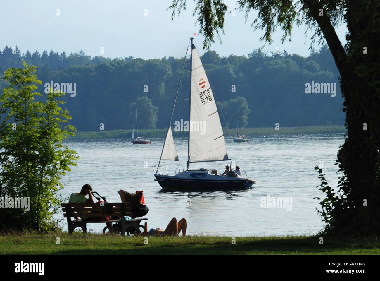 Barca a vela e turisti, Chiemsee, Chiemgau, Baviera, Germania Foto Stock