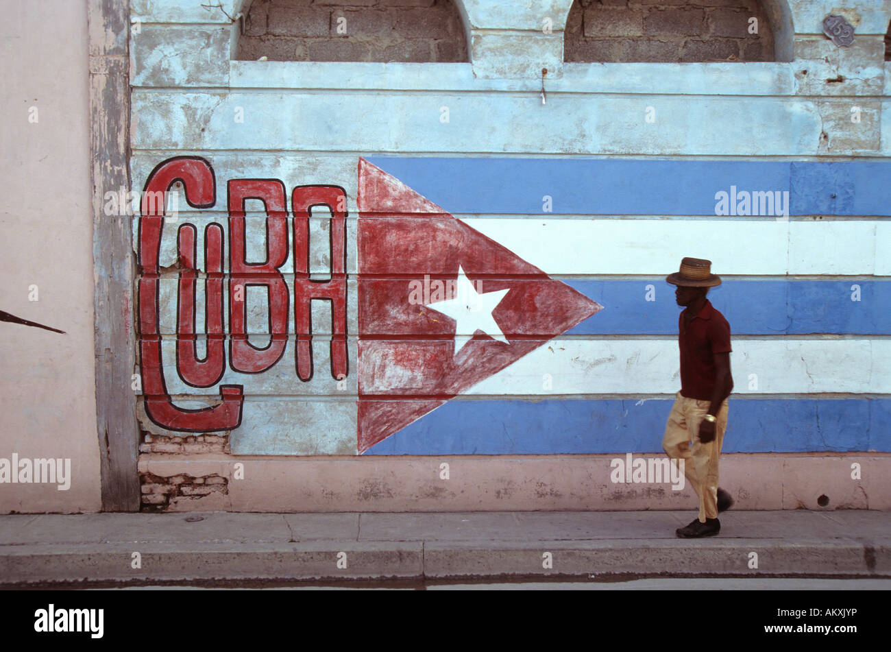 Il vecchio uomo per le strade di La Habana, bandiera cubana dipinta su un muro, Cuba Foto Stock