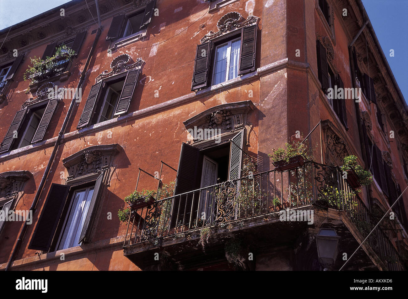 Una casa marrone nella zona di Trastevere di Roma con design scolpiti  attorno alle finestre e di piante in vaso sui balconi di Roma I Foto stock  - Alamy