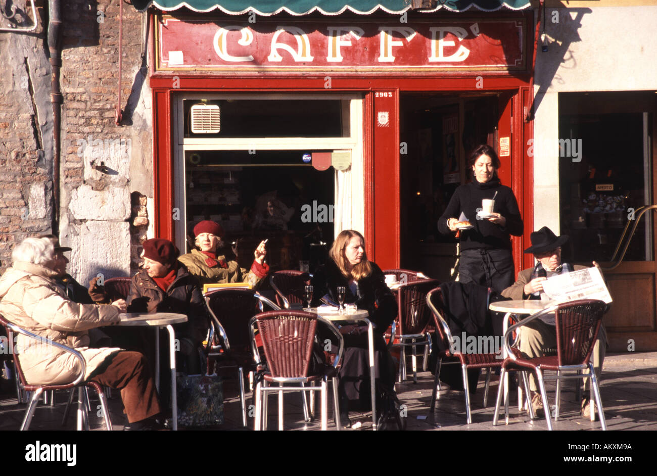 Venezia, Italia. Godendosi un po' di sole invernale al di fuori del Cafe Rosso sul Campo Santa Margherita nel sestiere di Dorsoduro. Foto Stock