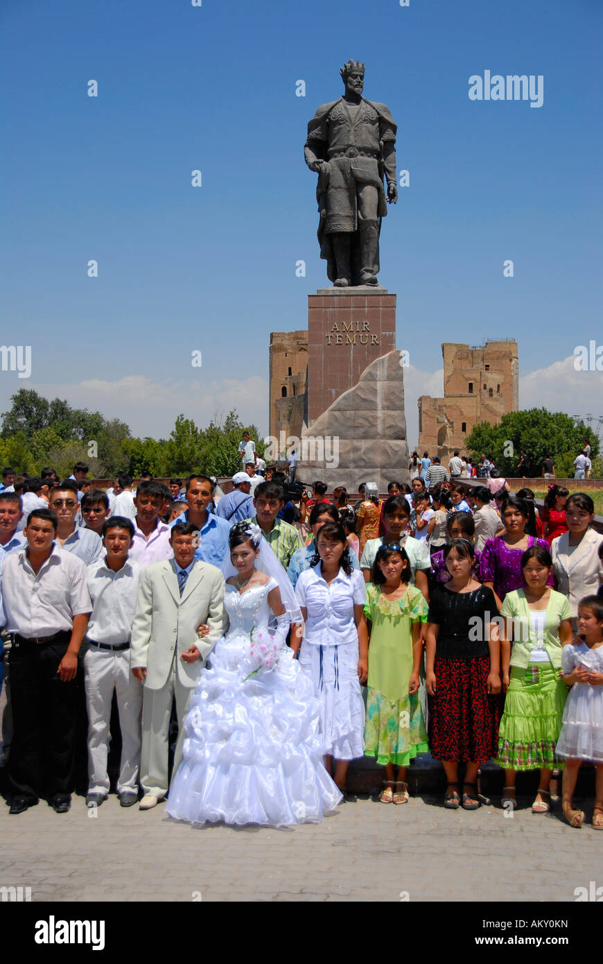 Molte persone di una cerimonia di matrimonio sotto il monumento di Amir Timur Shahrisabz Uzbekistan Foto Stock
