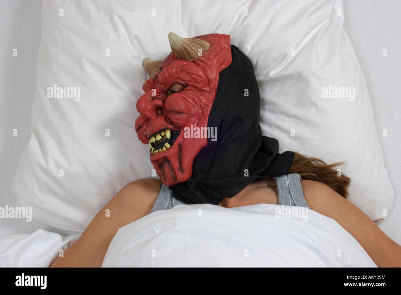 La donna addormentata con maschera del diavolo Foto Stock