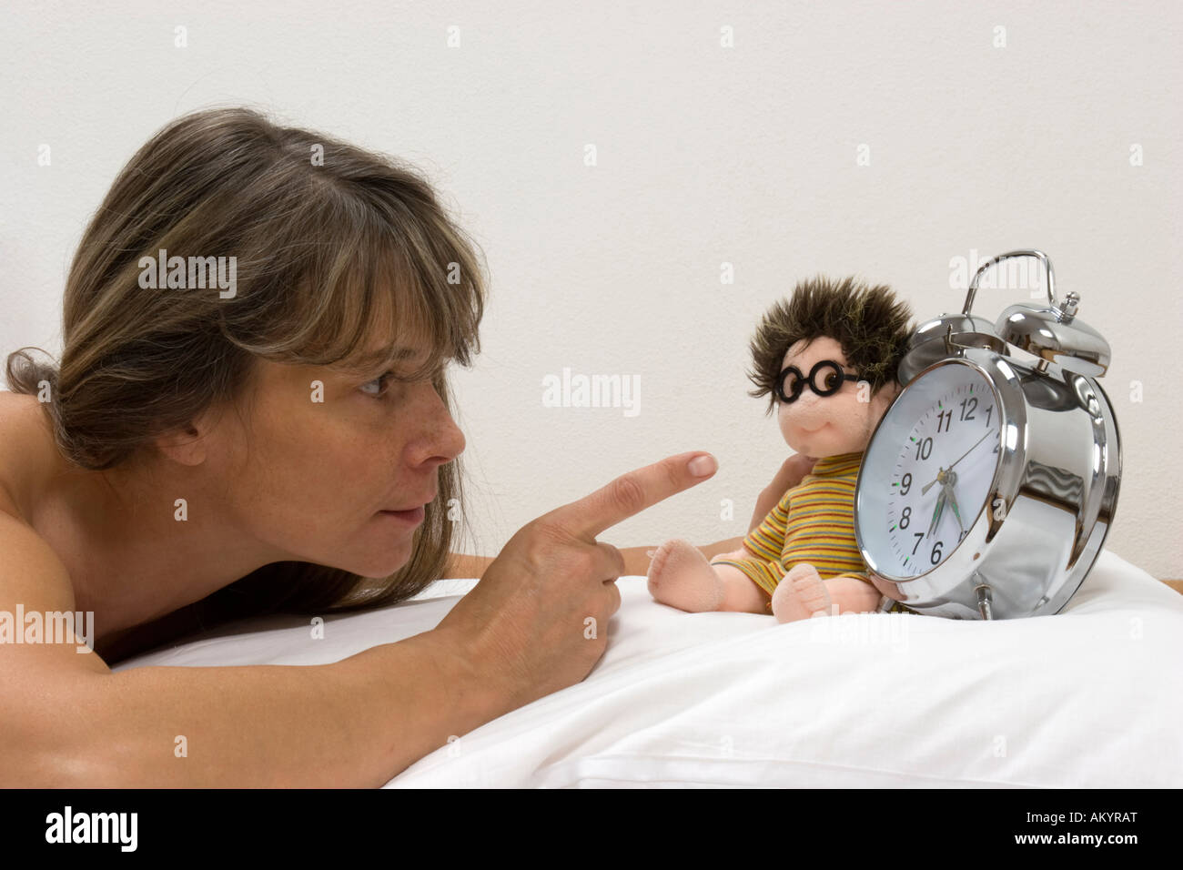 Donna con una bambola in letto Foto Stock