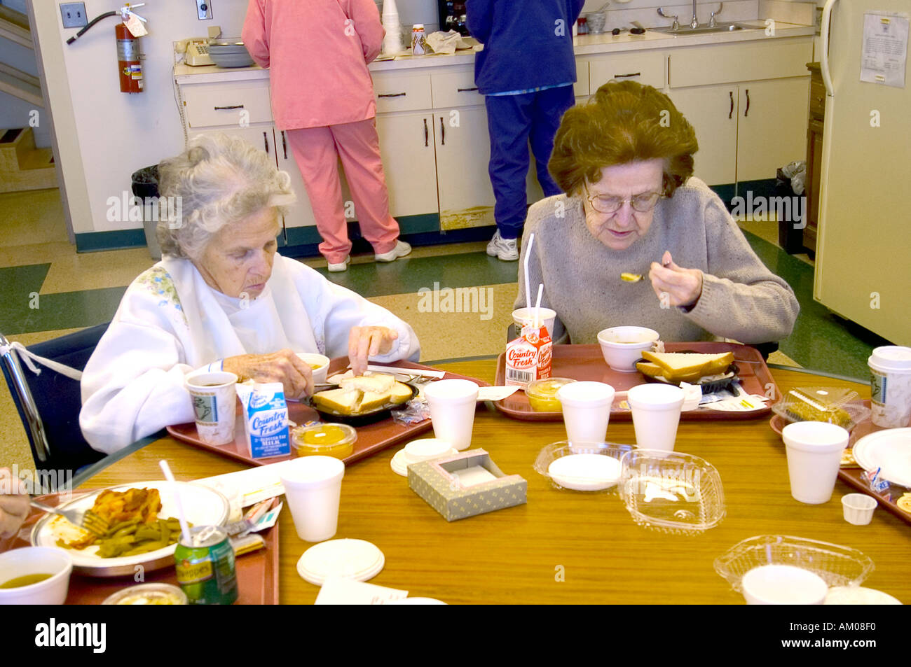 2 Senior femmine mangiare pranzo mentre la riabilitazione in ospedale dopo la malattia Foto Stock
