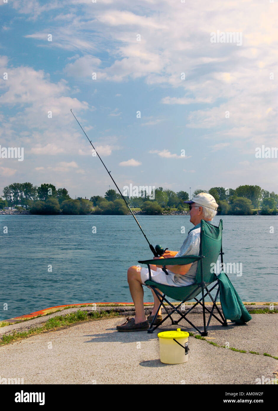 L'anziano uomo caucasico ama una tranquilla giornata di pesca sul panoramico fiume Niagara in Canada. Foto Stock