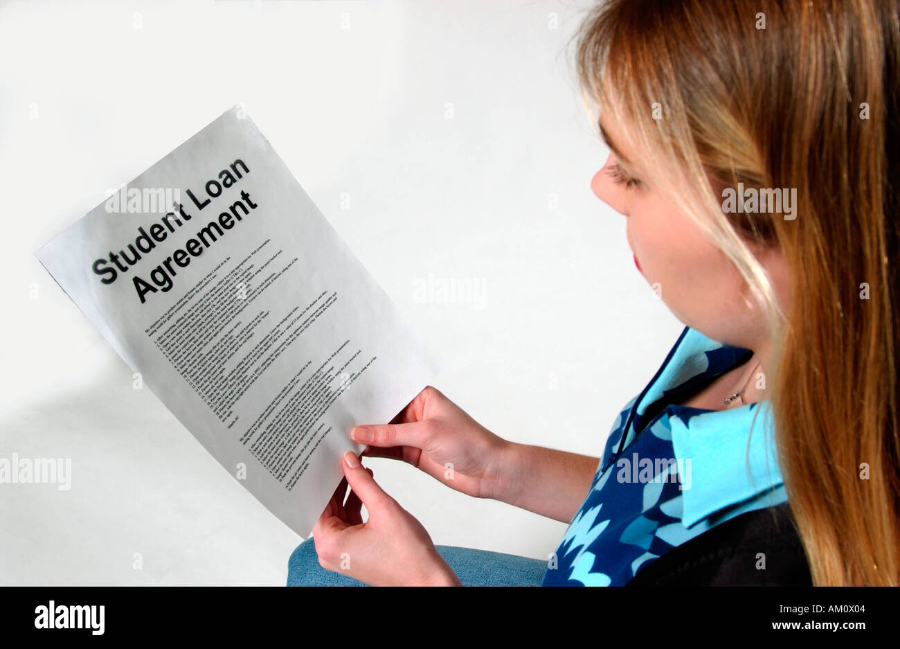 Giovane donna caucasica (18-20) legge l'accordo di prestito per studenti per i costi scolastici. STATI UNITI Foto Stock