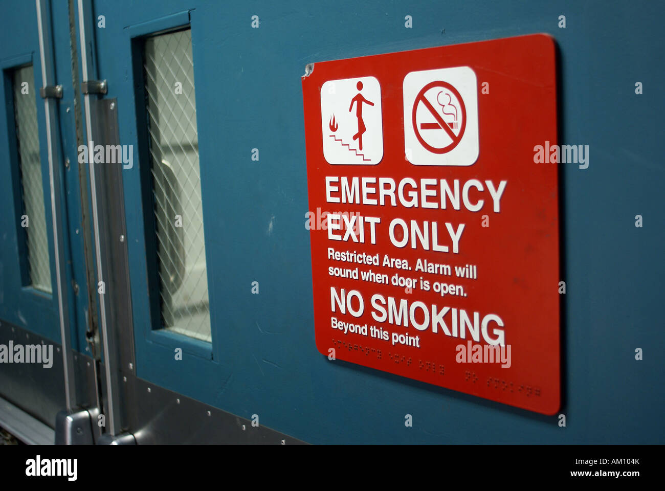 Segno: Uscita di emergenza solo e non fumare in corrispondenza di una porta di metallo Foto Stock