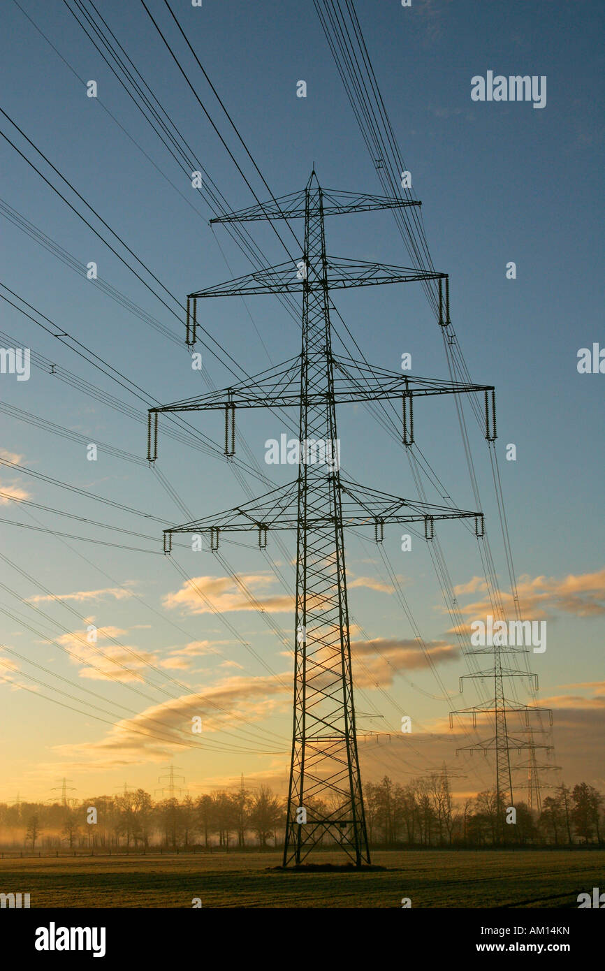 Poli di potenza alta tensione - Linee elettriche - sunrise in inverno mattina - Schleswig-Holstein, Germania, Europa Foto Stock