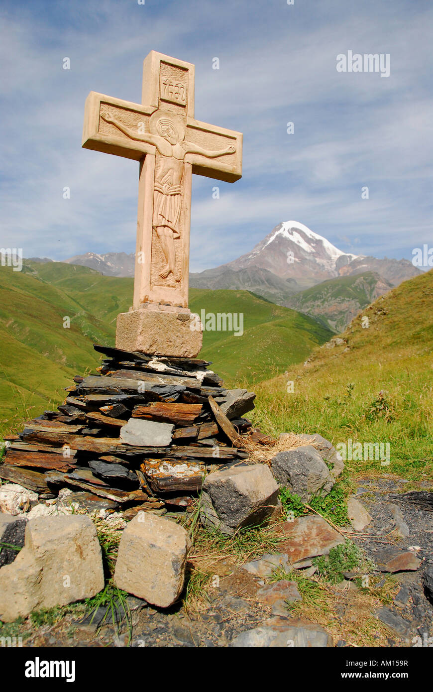 Croce alla Chiesa Gergeti davanti a 5047 metri di altezza Kasbeg picco, Kasbegi, Georgia Foto Stock