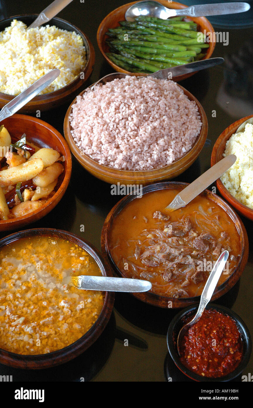 Tipico cibo bhutanesi: riso rosso, patatoes con peperoncino, asparagi, Thimphu Bhutan Foto Stock
