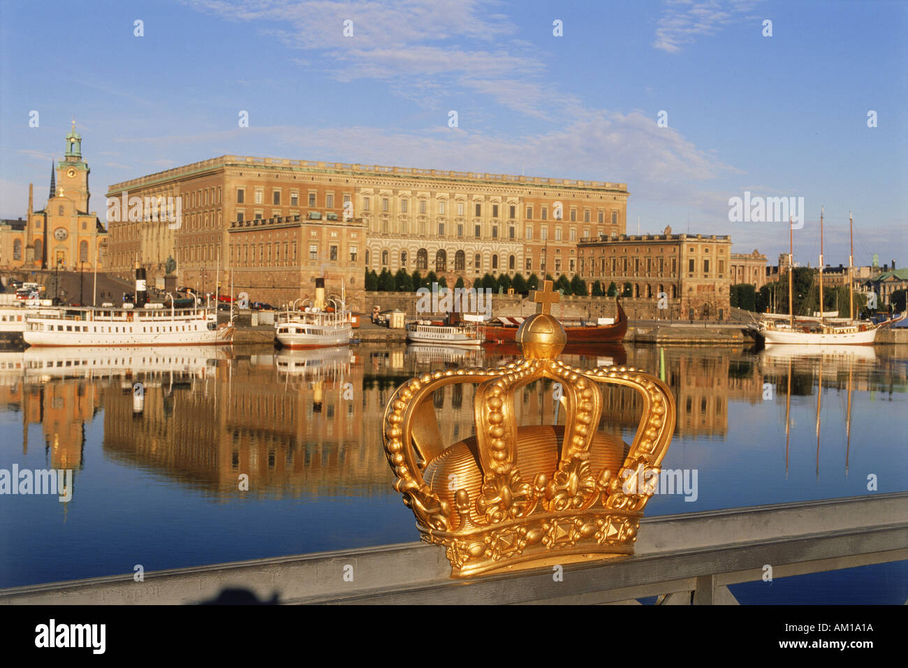 Golden crown sul ponte di Skeppsholmen con il Palazzo Reale di Stoccolma Foto Stock