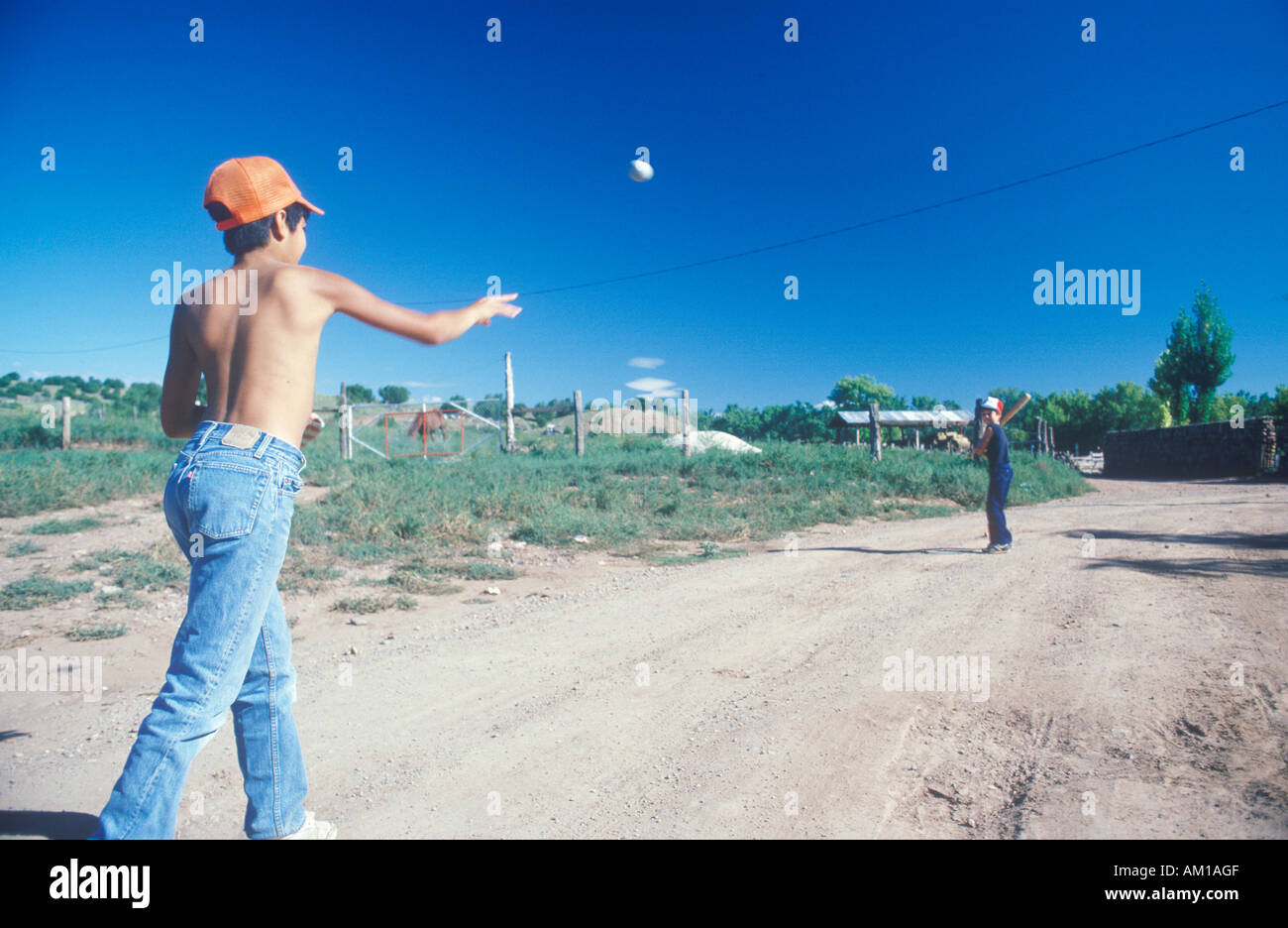 I ragazzi a giocare a baseball su una strada nel deserto San Miguel NM Foto Stock
