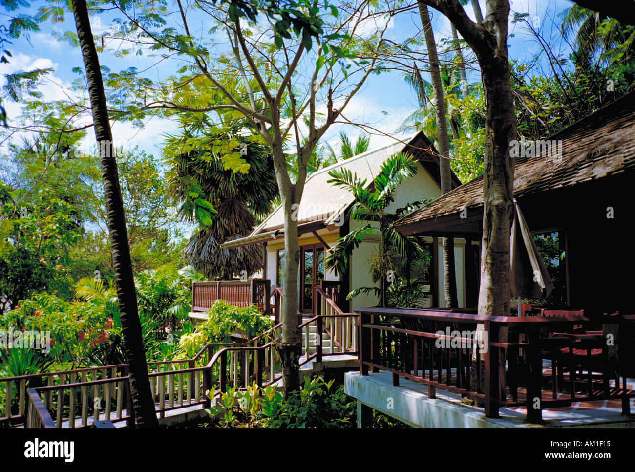 Il Central Samui Village hotel di Koh Samui comprende tradizionali chalet di legno tumbling giù un pendio boscoso al mare Foto Stock