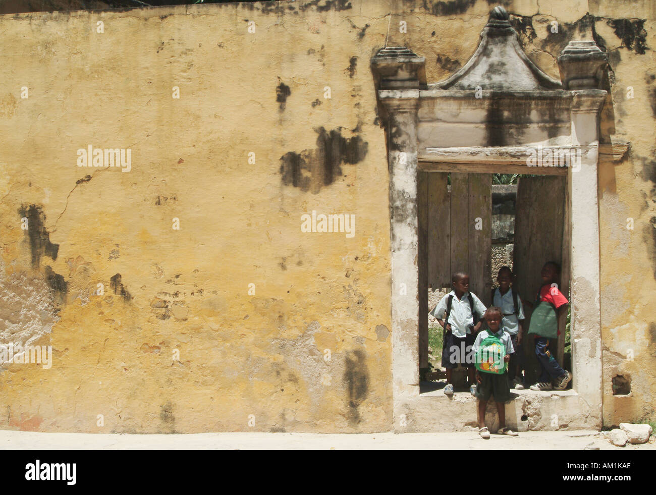 I bambini della scuola di stand alla porta di un Portoghese vecchio edificio coloniale sulla Ilha de Mocambique, Mozambico, Africa Foto Stock